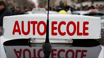 A car operated by a driving school instructor is seen during a protest against driving license reform in Paris