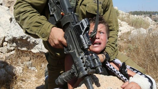 un-soldat-israelien-plaque-un-enfant-palestinien-sur-un-rocher-lors-d-affrontements-entre-les-forces-de-securite-israeliennes-et-des-manifestants-palestiniens-le-28-aout-2015-a-nabi-saleh-pres-de-ramallah-en-cisjordanie_5406377