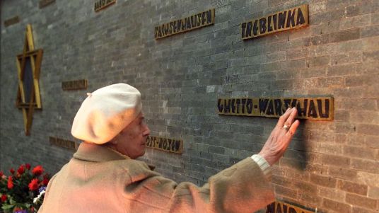 an-elderly-woman-touches-the-memorial-for-the-jewish-victims-of-the-nazi-holocaust-with-names-of-dif_5741755